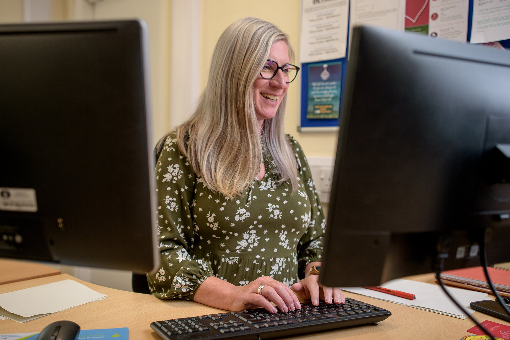 woman sat at computer, typing