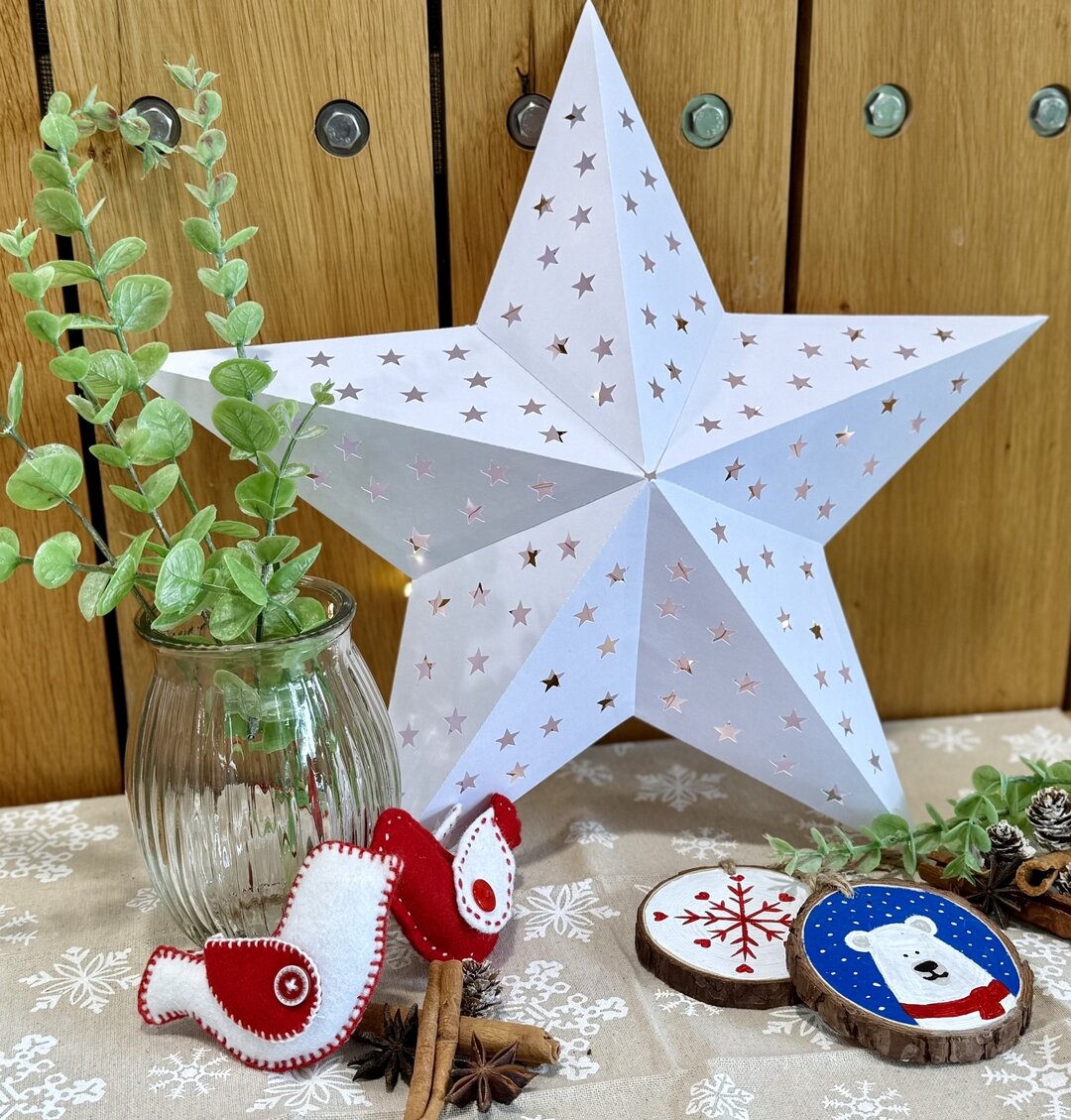 white paper star lantern with felt bird ornaments and painted wooden slice decorations