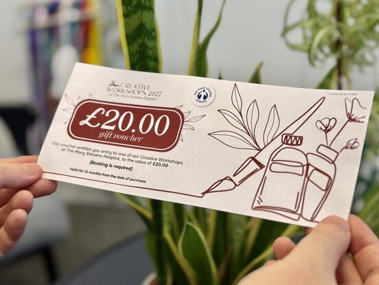 person holding creative workshop voucher