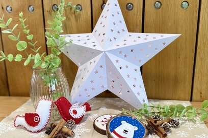 white paper star lantern with felt bird ornaments and painted wooden slice decorations