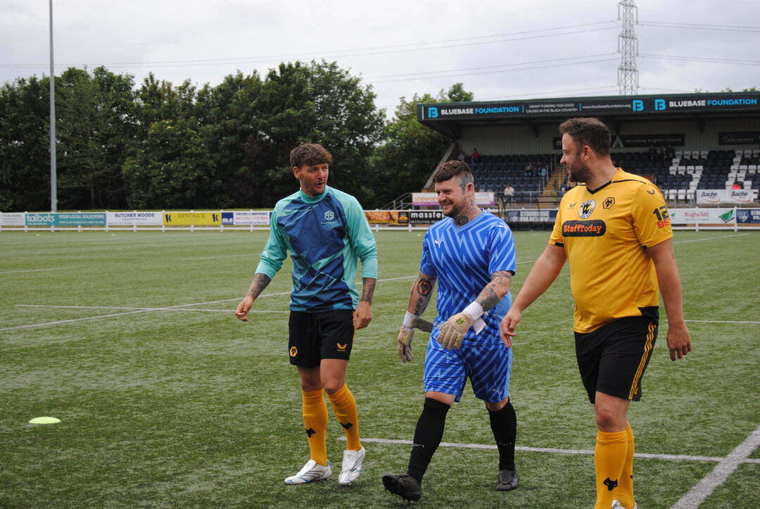 3 football players walking on a football pitch