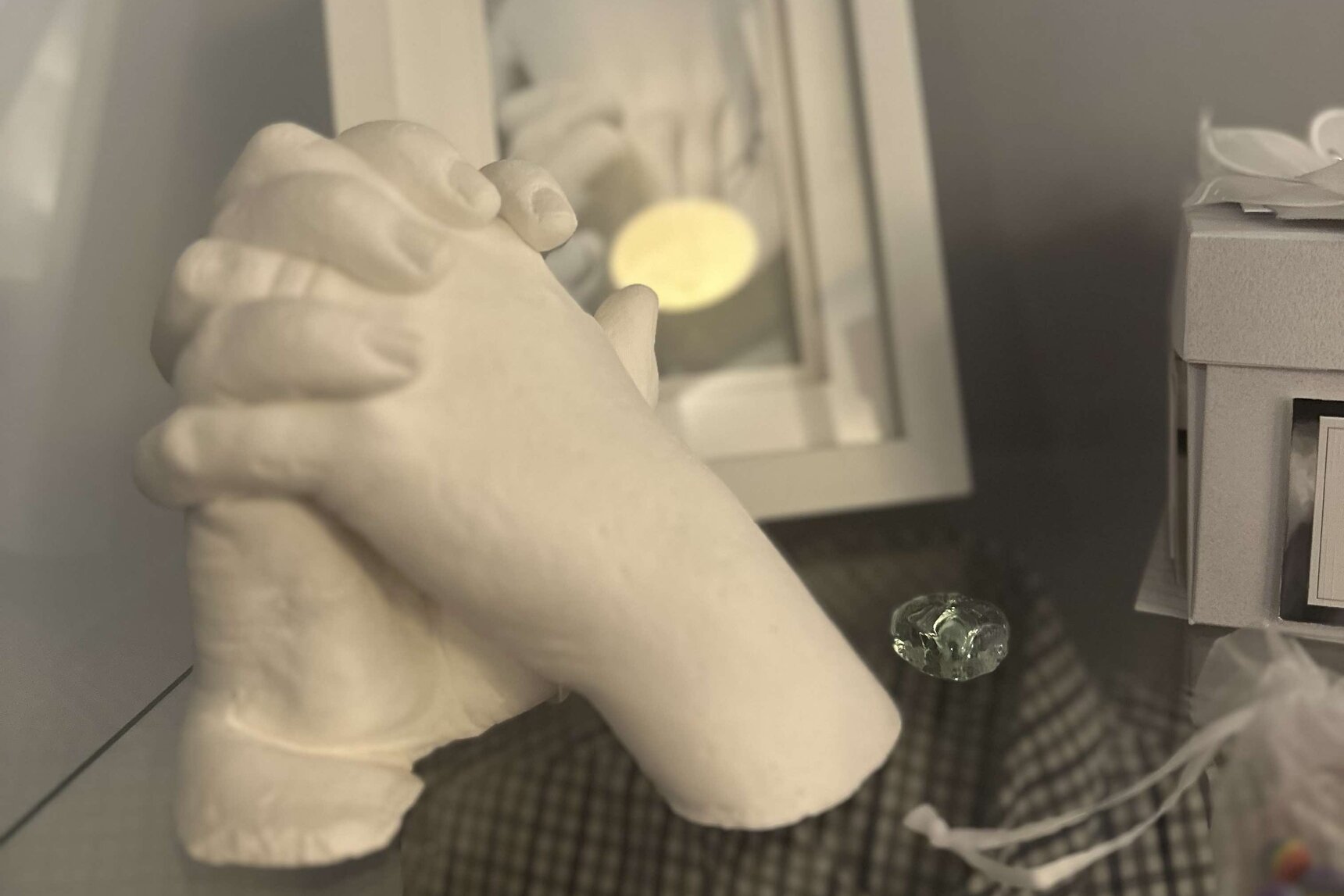 handcast of two hands holding on a glass shelf