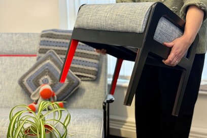 a person carrying a stool out of a living area