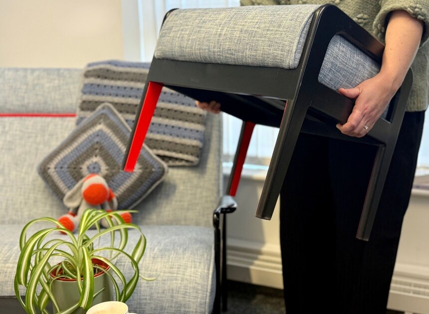 a person carrying a stool out of a living area