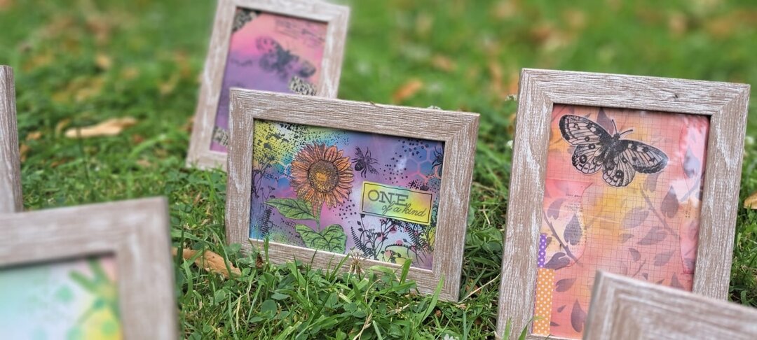 wooden frames, sat on green grass showing colourful ink pieces