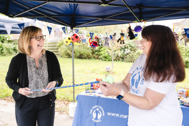Two women at a hook-a-duck stall at a fundraising event