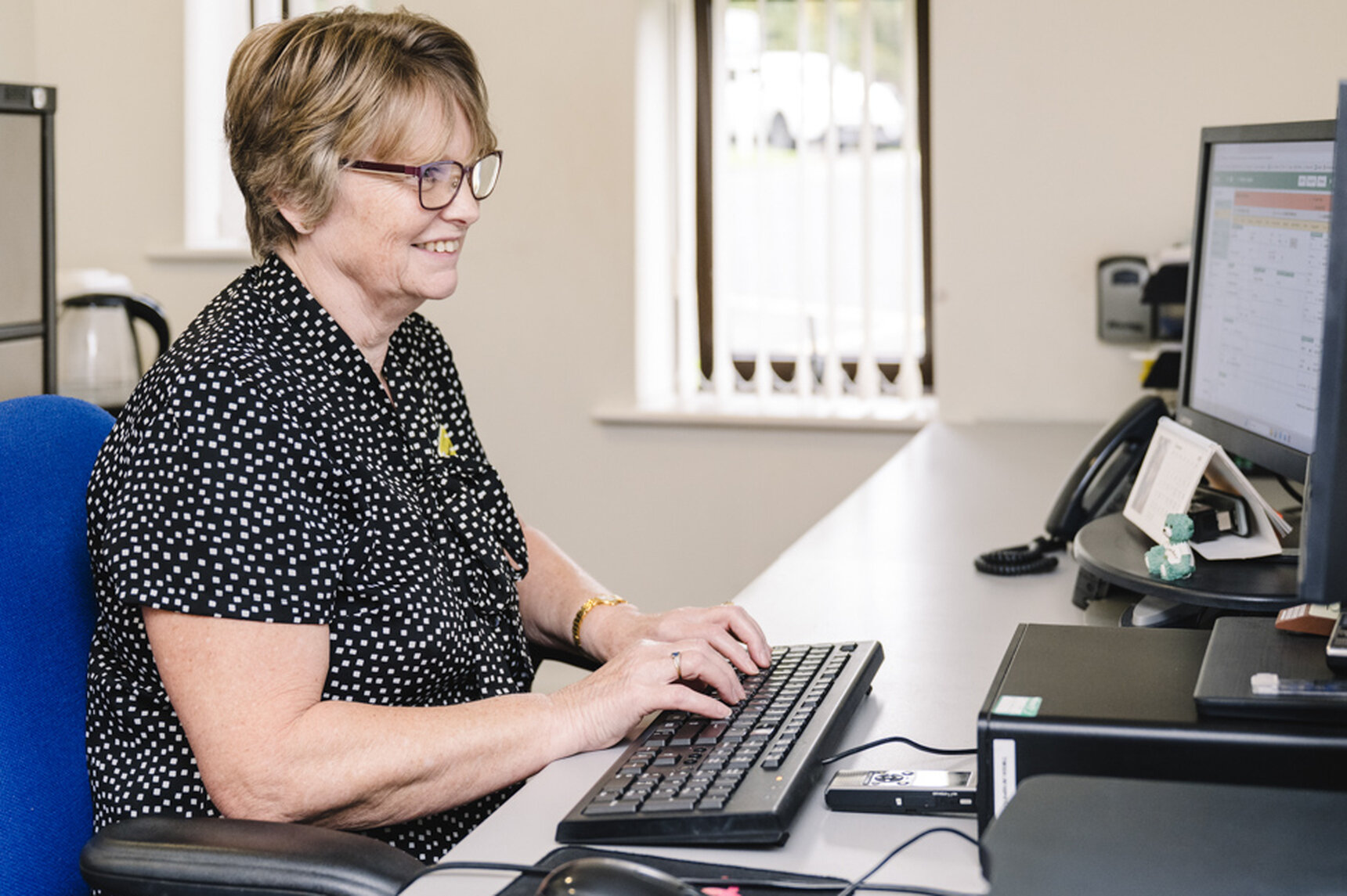 woman sat at computer, typing