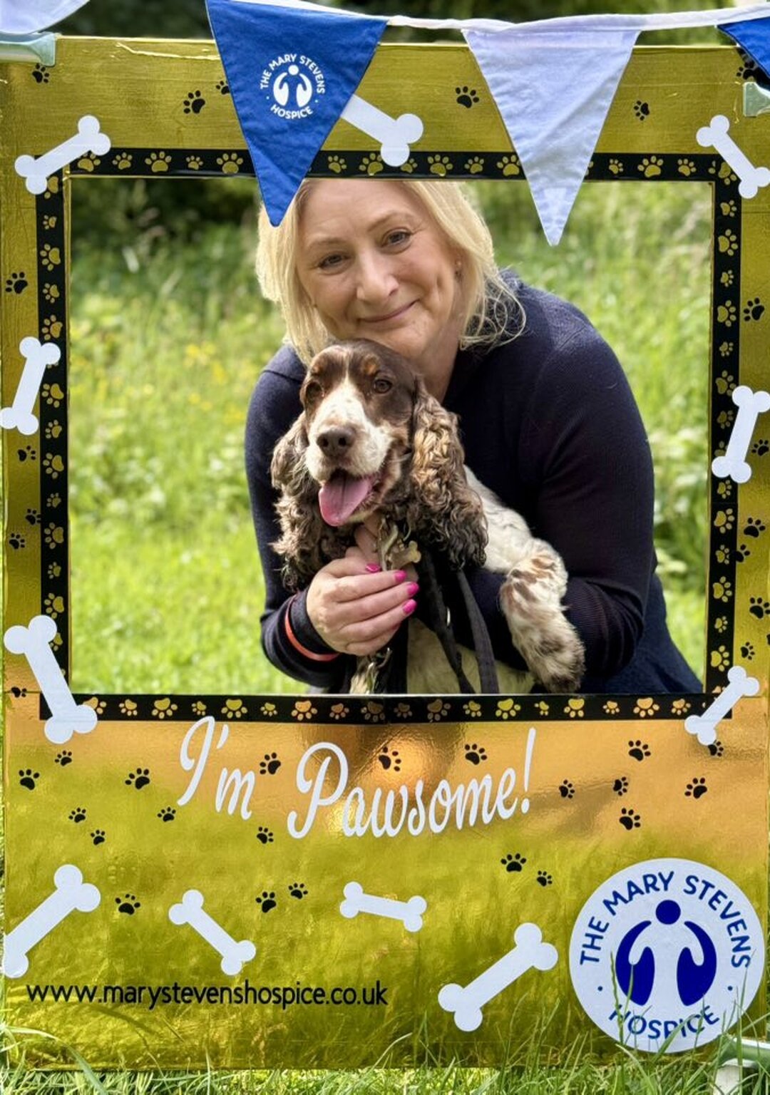happy, smiling lady with a dog, holding up a frame saying 'i'm pawsome!'
